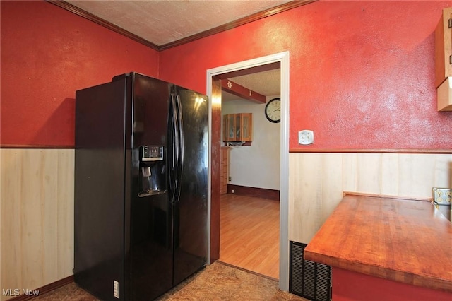 645 N Way St, Barberton, OH 44203 - kitchen with black fridge, ornamental molding, wood finished floors, and a textured ceiling