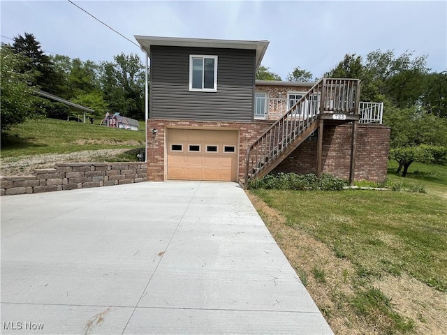 725 Logan Ave, Mingo Junction, OH 43938 - view of side of property featuring stairs, driveway, a lawn, and brick siding