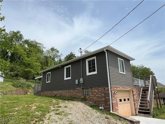 725 Logan Ave, Mingo Junction, OH 43938 - view of home's exterior featuring a garage, stairway, brick siding, and driveway