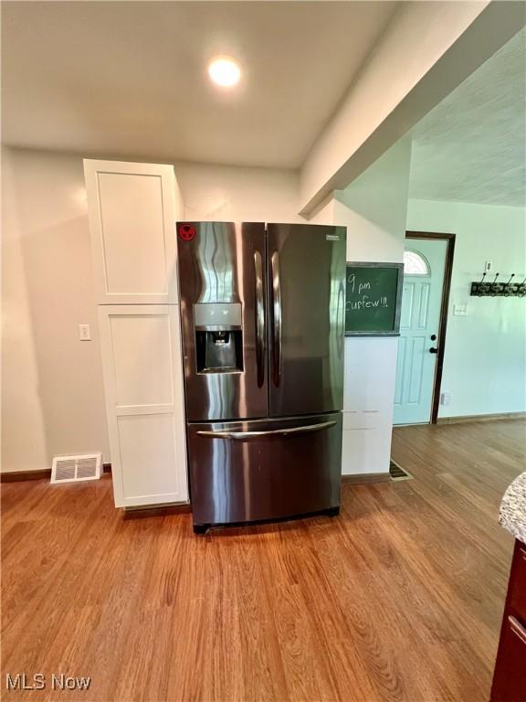 725 Logan Ave, Mingo Junction, OH 43938 - kitchen featuring stainless steel fridge, white cabinets, wood finished floors, and baseboards