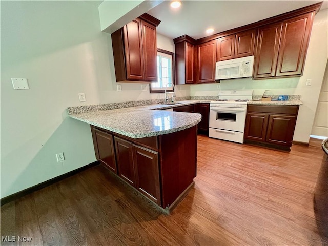 725 Logan Ave, Mingo Junction, OH 43938 - kitchen with white appliances, a peninsula, wood finished floors, a sink, and baseboards