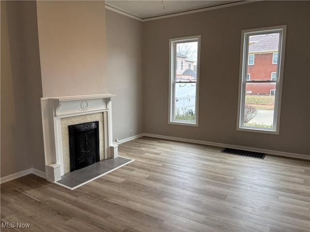 1278 Euclid Ave, Zanesville, OH 43701 - unfurnished living room featuring crown molding, wood finished floors, baseboards, a tiled fireplace, and healthy amount of natural light