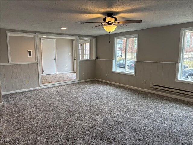 1278 Euclid Ave, Zanesville, OH 43701 - carpeted spare room with a textured ceiling, a wainscoted wall, plenty of natural light, a ceiling fan, and a baseboard heating unit