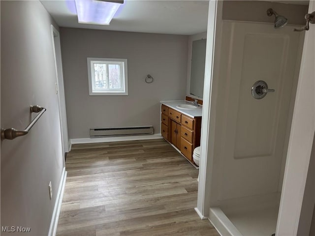 1278 Euclid Ave, Zanesville, OH 43701 - full bathroom with baseboard heating, vanity, a shower stall, wood finished floors, and baseboards