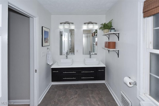 17917 Scottsdale Blvd, Shaker Heights, OH 44122 - bathroom featuring baseboards, double vanity, curtained shower, and a textured ceiling