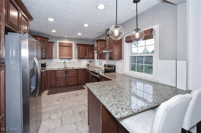 17917 Scottsdale Blvd, Shaker Heights, OH 44122 - kitchen featuring stainless steel appliances, a sink, under cabinet range hood, a peninsula, and light stone countertops