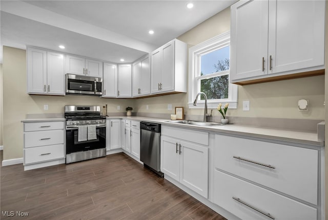 5325 Jefferson Ave, Ashtabula, OH 44004 - kitchen with appliances with stainless steel finishes, a sink, white cabinets, dark wood-type flooring, and light countertops