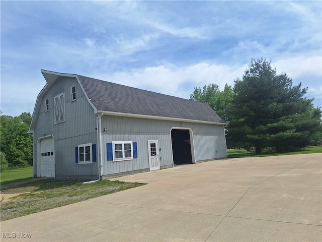 16604 Old State Rd, Middlefield, OH 44062 - view of side of home featuring a detached garage, roof with shingles, and an outbuilding