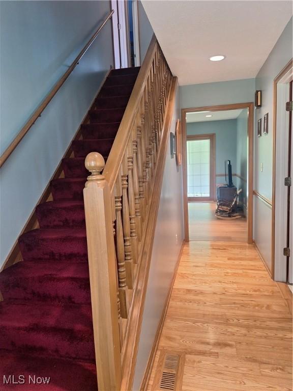 16604 Old State Rd, Middlefield, OH 44062 - stairs featuring wood finished floors, a wood stove, and baseboards