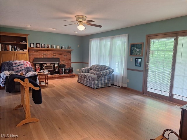 16604 Old State Rd, Middlefield, OH 44062 - living room with wood finished floors, ceiling fan, a brick fireplace, and baseboards