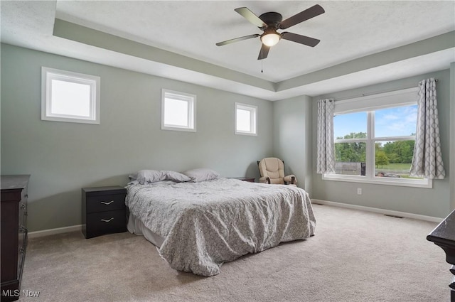 2562 Gianni Way, Richfield, OH 44286 - bedroom with baseboards, light carpet, a raised ceiling, and a ceiling fan