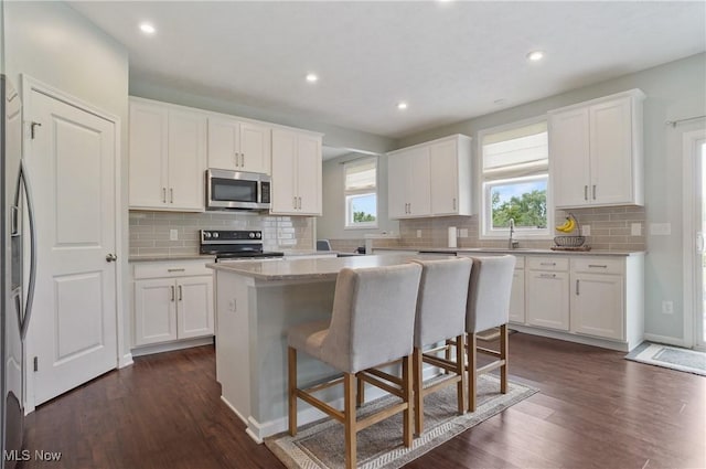2562 Gianni Way, Richfield, OH 44286 - kitchen with appliances with stainless steel finishes, backsplash, dark wood-type flooring, white cabinets, and recessed lighting