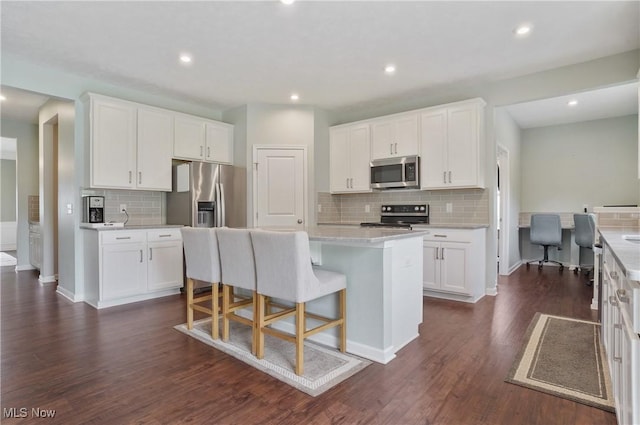 2562 Gianni Way, Richfield, OH 44286 - kitchen with stainless steel appliances, decorative backsplash, white cabinetry, a kitchen breakfast bar, and recessed lighting