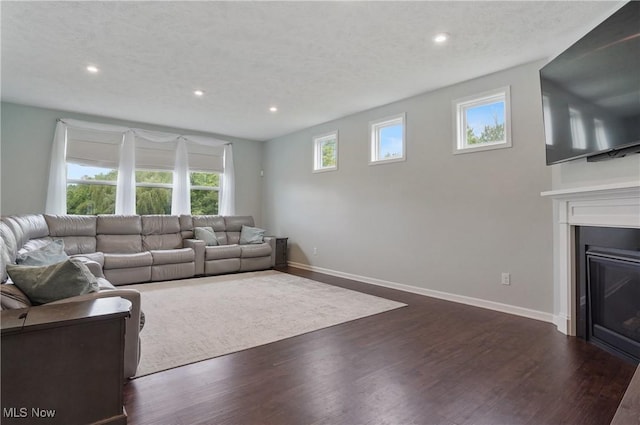 2562 Gianni Way, Richfield, OH 44286 - living room featuring dark wood-style flooring, recessed lighting, a glass covered fireplace, and baseboards