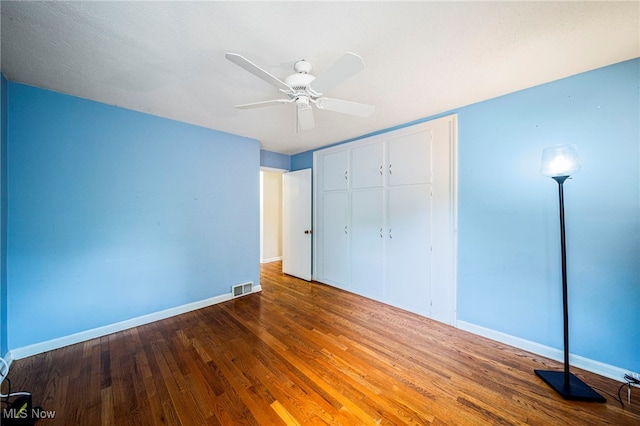 2039 S Green Rd, South Euclid, OH 44121 - unfurnished bedroom featuring wood finished floors, baseboards, a closet, and ceiling fan