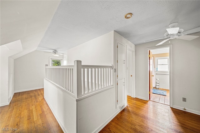2039 S Green Rd, South Euclid, OH 44121 - corridor featuring wood finished floors, an upstairs landing, a textured ceiling, baseboards, and lofted ceiling
