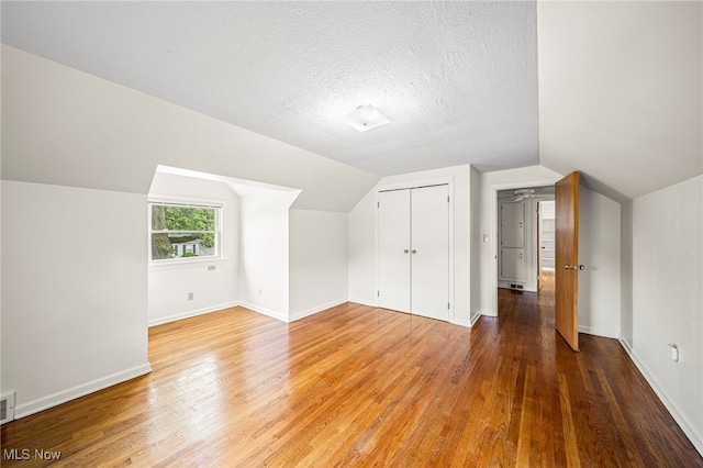 2039 S Green Rd, South Euclid, OH 44121 - additional living space featuring light wood-style flooring, vaulted ceiling, baseboards, and a textured ceiling