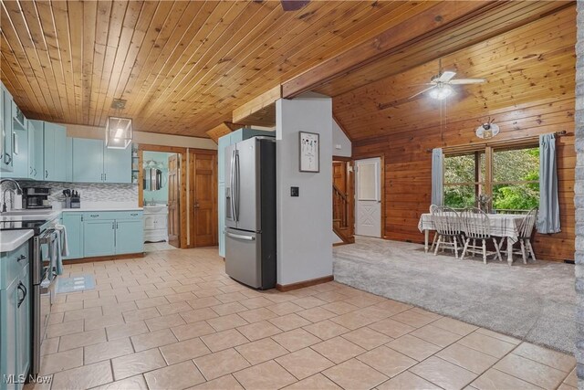 9434 Trinity Church Rd, Lisbon, OH 44432 - kitchen featuring stainless steel appliances, light countertops, blue cabinetry, wood walls, and backsplash