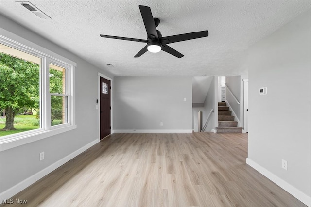 4426 Dueber Ave SW, Canton, OH 44706 - unfurnished living room with a textured ceiling, wood finished floors, baseboards, a ceiling fan, and stairs