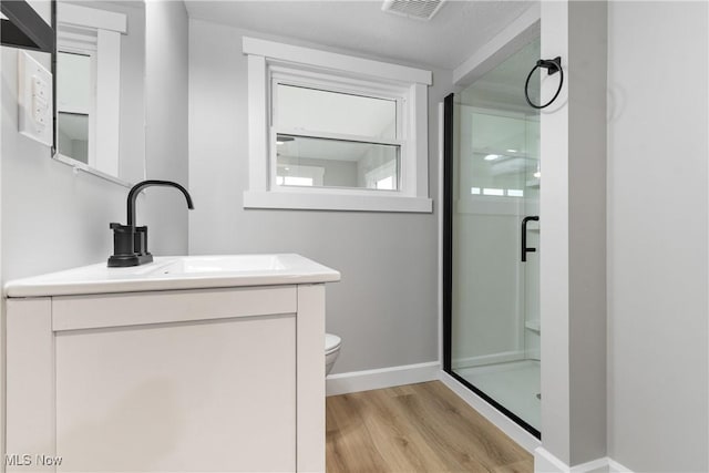 4426 Dueber Ave SW, Canton, OH 44706 - bathroom with wood finished floors, a stall shower, vanity, and toilet