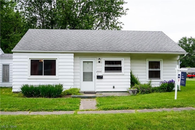 2007 W 59th St, Ashtabula, OH 44004 - view of front of house with roof with shingles and a front lawn