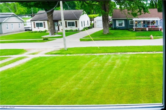 2007 W 59th St, Ashtabula, OH 44004 - view of green lawn with concrete driveway and a garage