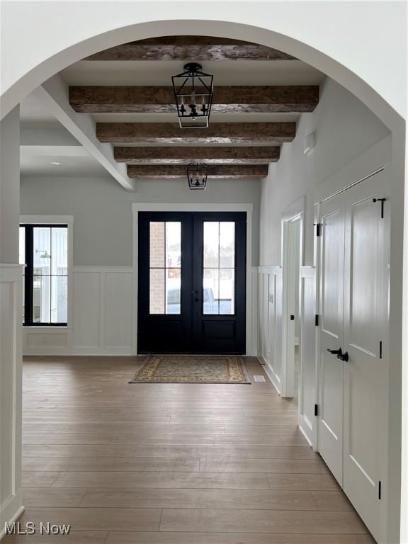 275 Glengarry Dr, Aurora, OH 44202 - foyer entrance featuring beamed ceiling, a decorative wall, light wood-style flooring, french doors, and a wainscoted wall
