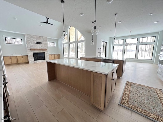 275 Glengarry Dr, Aurora, OH 44202 - kitchen featuring a large island with sink, a sink, open floor plan, a ceiling fan, and a stone fireplace