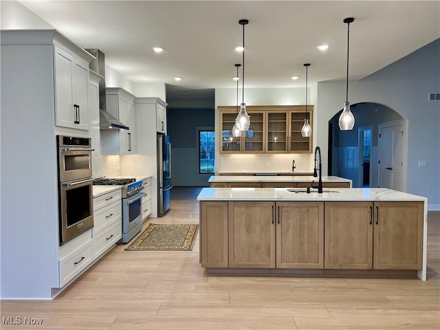 275 Glengarry Dr, Aurora, OH 44202 - kitchen featuring appliances with stainless steel finishes, a sink, a large island, arched walkways, and tasteful backsplash