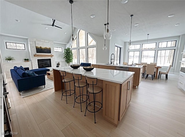 275 Glengarry Dr, Aurora, OH 44202 - kitchen with a large island with sink, a sink, ceiling fan, a large fireplace, and open floor plan