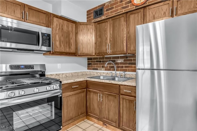 3304 Tangent St, Youngstown, OH 44502 - kitchen with stainless steel appliances, a sink, brown cabinetry, and light tile patterned floors