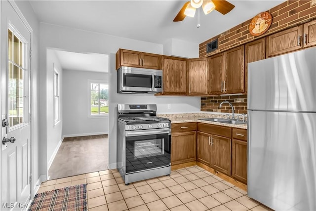 3304 Tangent St, Youngstown, OH 44502 - kitchen with appliances with stainless steel finishes, a sink, brown cabinets, ceiling fan, and tasteful backsplash