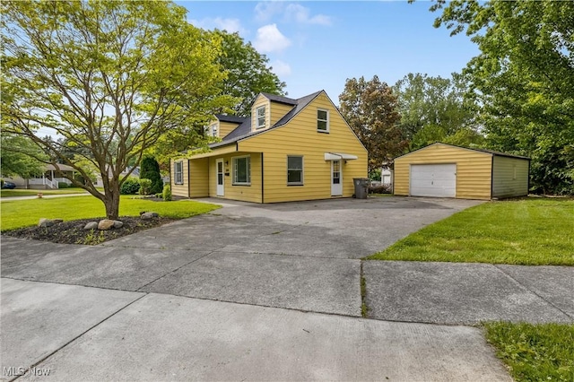 3304 Tangent St, Youngstown, OH 44502 - view of front facade with an outdoor structure, asphalt driveway, a detached garage, and a front lawn