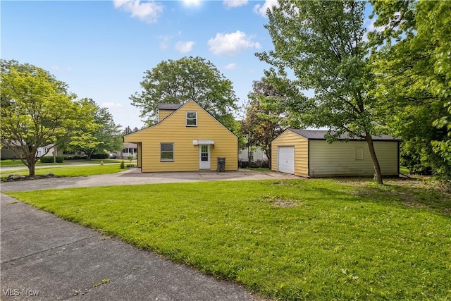 3304 Tangent St, Youngstown, OH 44502 - view of side of home featuring an outdoor structure, a detached garage, a lawn, and driveway