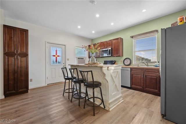 10366 Immel St NE, Canton, OH 44721 - kitchen with stainless steel appliances, a kitchen breakfast bar, light countertops, light wood-type flooring, and recessed lighting