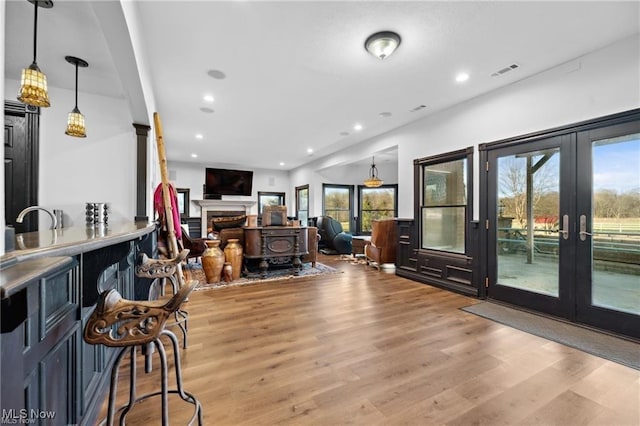 10366 Immel St NE, Canton, OH 44721 - living room featuring french doors, light wood-style floors, plenty of natural light, recessed lighting, and a fireplace