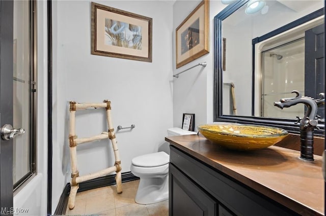 10366 Immel St NE, Canton, OH 44721 - bathroom featuring a shower with shower door, vanity, tile patterned floors, and toilet