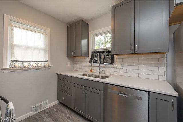 5963 Porter Rd, North Olmsted, OH 44070 - kitchen with dishwasher, gray cabinetry, a sink, wood finished floors, and decorative backsplash