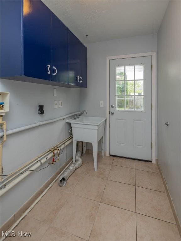 5963 Porter Rd, North Olmsted, OH 44070 - washroom featuring light tile patterned floors, cabinet space, and baseboards