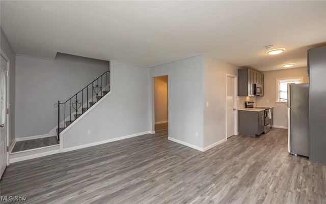 5963 Porter Rd, North Olmsted, OH 44070 - unfurnished living room with wood finished floors, stairs, and baseboards
