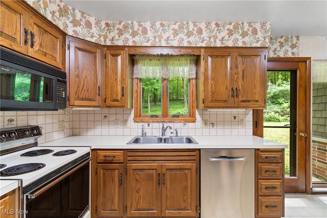 4512 Conestoga Trl, Copley, OH 44321 - kitchen featuring electric range oven, stainless steel dishwasher, a sink, black microwave, and wallpapered walls