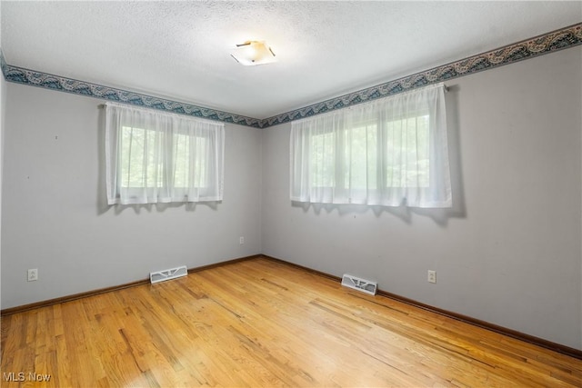 4512 Conestoga Trl, Copley, OH 44321 - spare room featuring light wood-type flooring, baseboards, and a textured ceiling