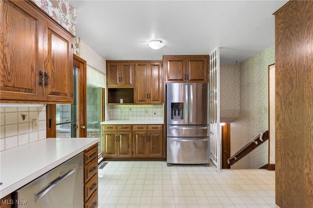 4512 Conestoga Trl, Copley, OH 44321 - kitchen featuring stainless steel appliances, wallpapered walls, light countertops, light flooring, and backsplash
