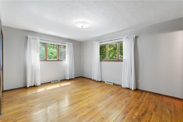 4512 Conestoga Trl, Copley, OH 44321 - empty room with light wood finished floors, healthy amount of natural light, a textured ceiling, and baseboards