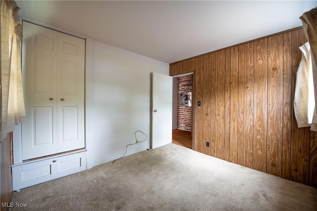 142 Marion Ave, Mogadore, OH 44260 - unfurnished bedroom featuring carpet floors, wood walls, and a closet