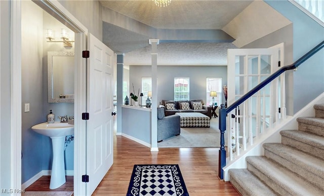 218 Treetop Spur, Copley, OH 44321 - foyer entrance with baseboards, wood finished floors, stairway, a textured ceiling, and ornate columns
