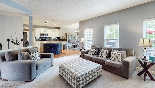 218 Treetop Spur, Copley, OH 44321 - living area with a chandelier, a textured ceiling, recessed lighting, light colored carpet, and light wood-style floors