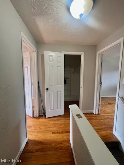 23855 Banbury Cir, Warrensville Heights, OH 44128 - corridor with wood finished floors, baseboards, and a textured ceiling