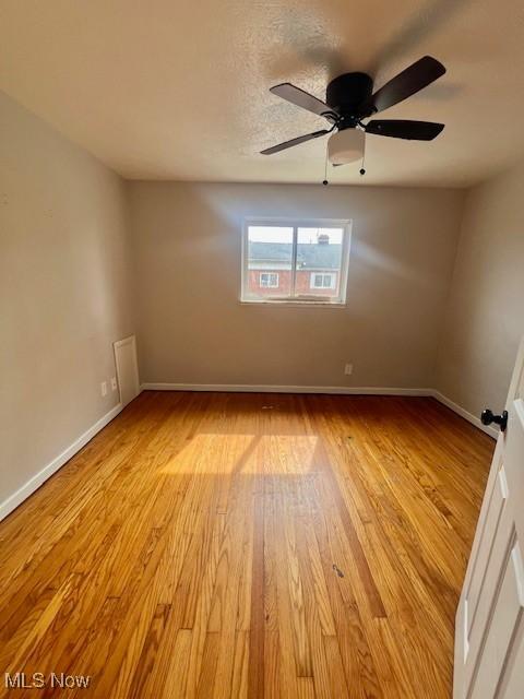 23855 Banbury Cir, Warrensville Heights, OH 44128 - empty room featuring light wood-type flooring, baseboards, and a ceiling fan