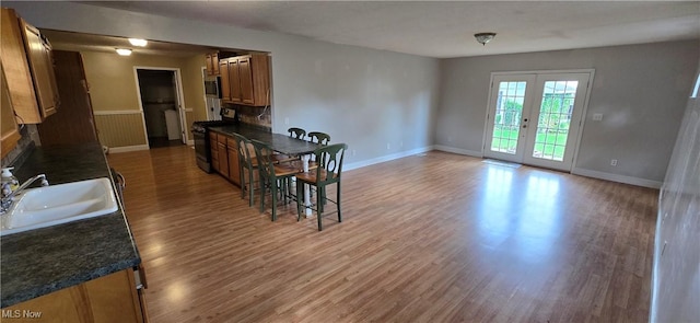 4604 7th Ave, Vienna, WV 26105 - kitchen with black gas range, a sink, dark countertops, and wood finished floors